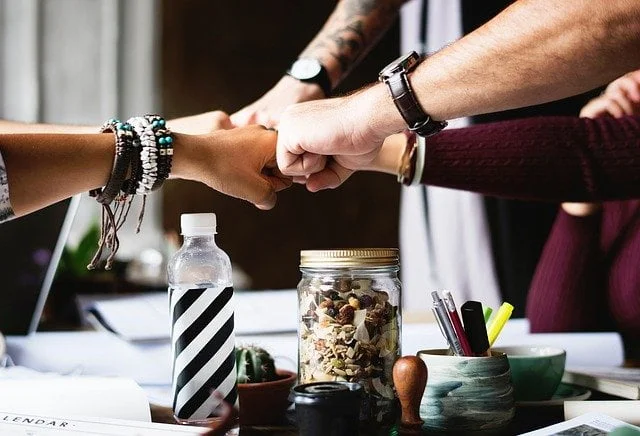 Inpatients sharing a fist-bump at a drug and alcohol rehab clinic in Exeter