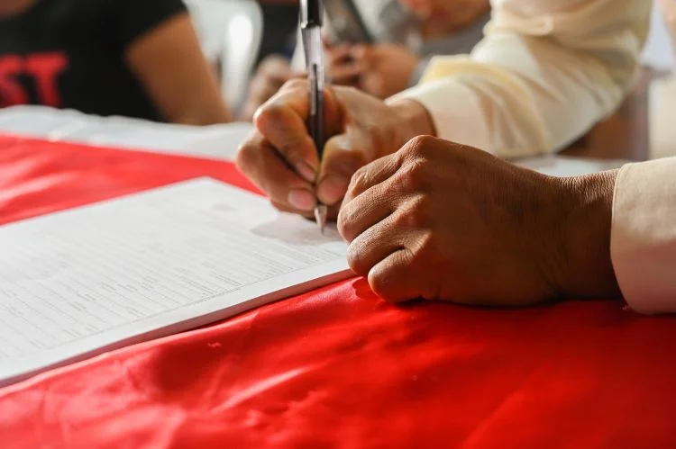 A person signing paperwork at a rehab in Sunderland