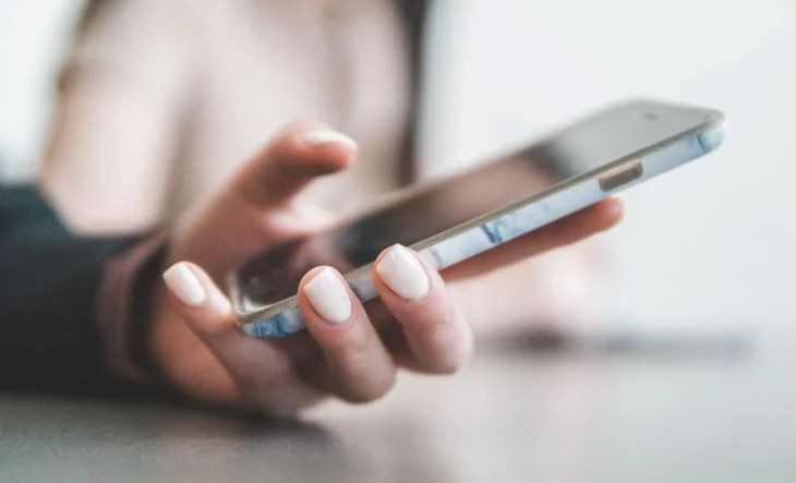 Person typing on a phone at a drug and alcohol rehab in Bolton