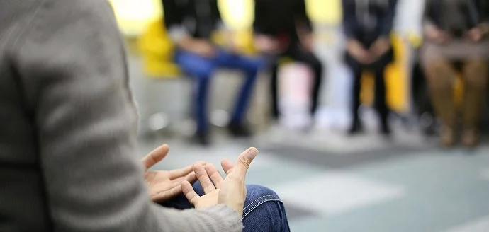 A group of people in chairs at an alcohol rehab in Bournemouth