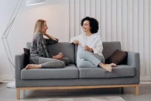 Two people sitting on a couch talking