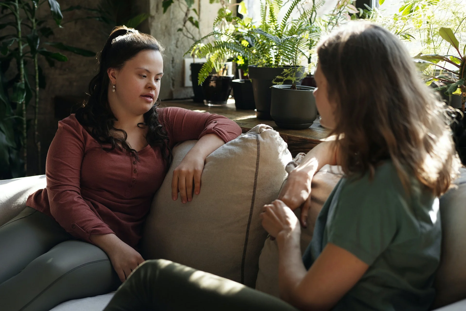 two women talking on a sofa together