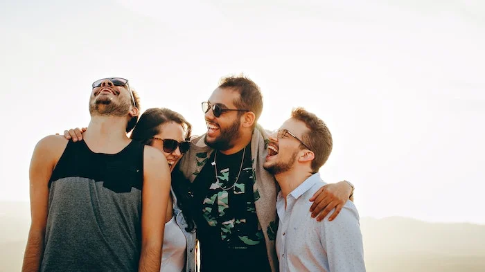 A group of friends laughing and drinking alcohol