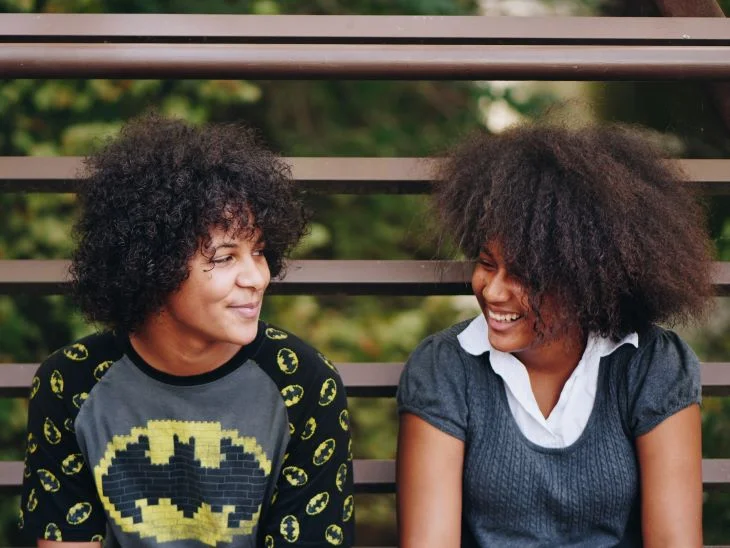 Two women chatting and smiling on a bench