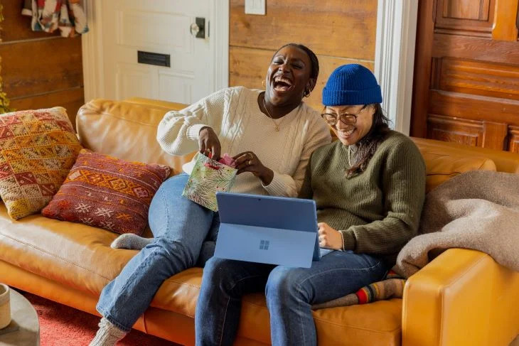 Two women laughing on a sofa in Bournemouth