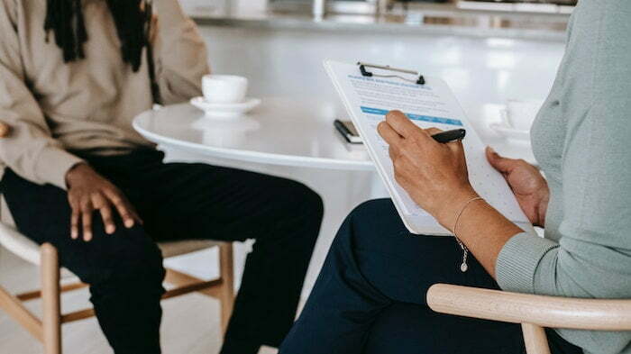 Addiction worker taking notes whilst speaking with a patient about Lortab addiction