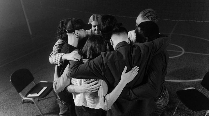 Black and white photo of people at their first addiction recovery meeting