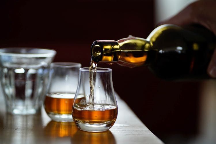 A bartender pouring two spirits