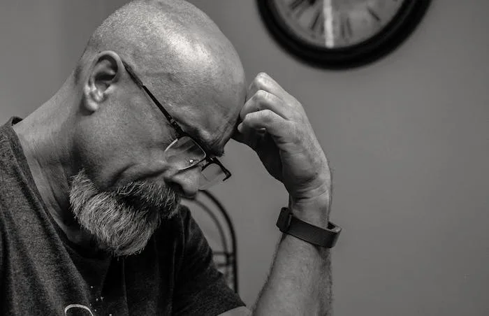 Man holding his head at a drug rehab and alcohol rehab in Bolton or near Bolton