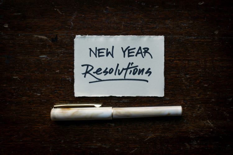 A scrap of paper saying 'New year resolutions' and a pen